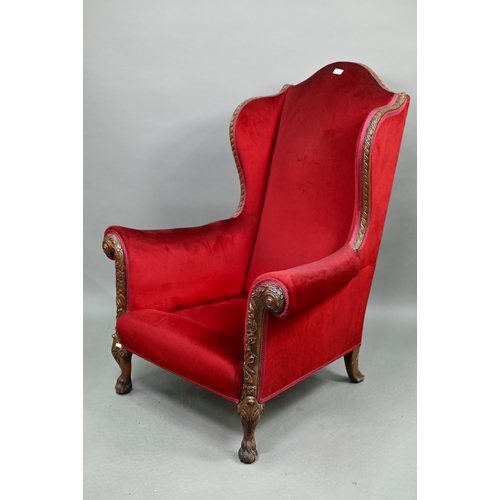 713 - A carved and moulded walnut framed burgundy plush upholstered armchair, with hump back over scroll a... 