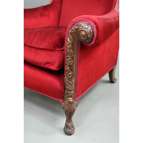 713 - A carved and moulded walnut framed burgundy plush upholstered armchair, with hump back over scroll a... 