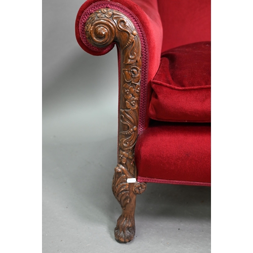 713 - A carved and moulded walnut framed burgundy plush upholstered armchair, with hump back over scroll a... 