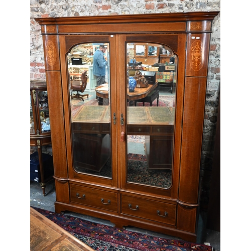 717 - AMENDED ESTIMATE An Edwardian Sheraton Revival inlaid satin walnut wardrobe, the twin mirrored doors... 