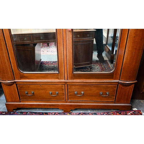 717 - AMENDED ESTIMATE An Edwardian Sheraton Revival inlaid satin walnut wardrobe, the twin mirrored doors... 