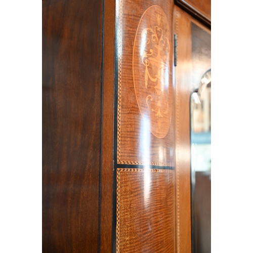 717 - AMENDED ESTIMATE An Edwardian Sheraton Revival inlaid satin walnut wardrobe, the twin mirrored doors... 