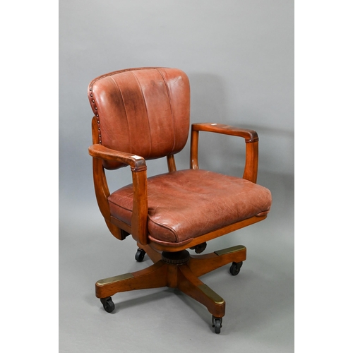 718 - A vintage American brown leather upholstered overstuffed swivel seat office chair by Sikes, on brass... 