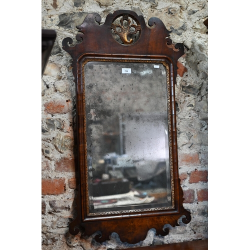 724 - An antique parcel gilt walnut fret cut mirror with distressed plate, 52 cm w x 94 cm h