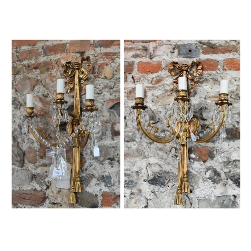 726 - A pair of Regency style ribbon and swag triple arm gilt metal wall sconces, crystal strung, 60 cm h ... 