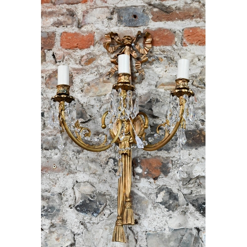 726 - A pair of Regency style ribbon and swag triple arm gilt metal wall sconces, crystal strung, 60 cm h ... 