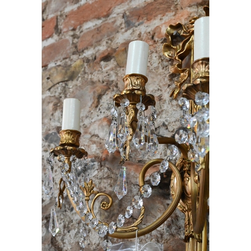 726 - A pair of Regency style ribbon and swag triple arm gilt metal wall sconces, crystal strung, 60 cm h ... 