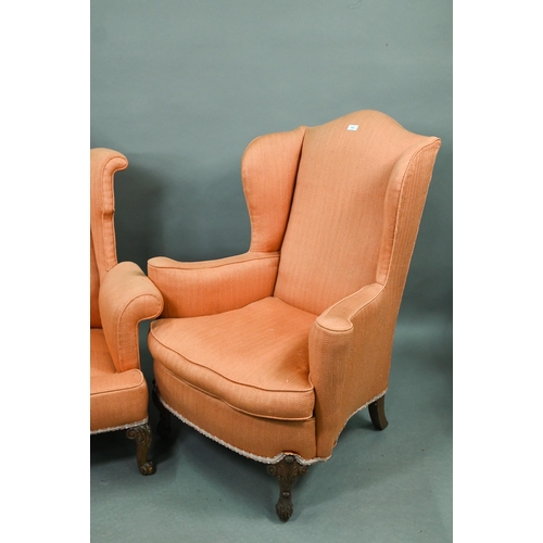 728 - Two similar hump wing-back armchairs with orange upholstery, raised on carved and cabriole front leg... 