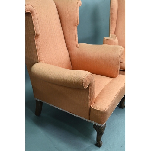 728 - Two similar hump wing-back armchairs with orange upholstery, raised on carved and cabriole front leg... 