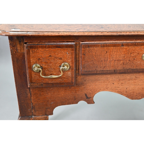 730 - An 18th century oak three drawer lowboy within a shaped apron, raised on cabriole legs to pad feet, ... 