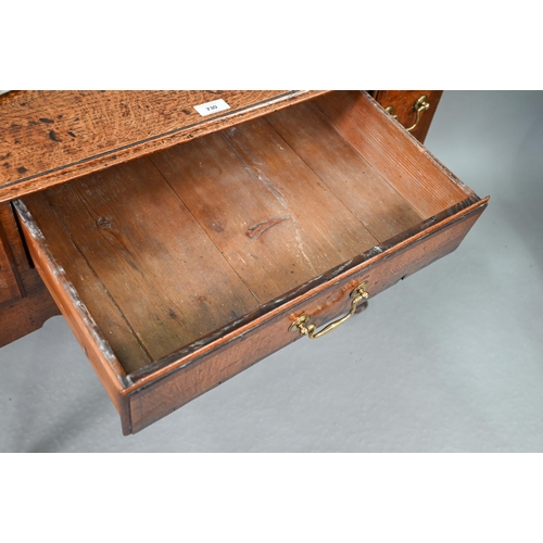 730 - An 18th century oak three drawer lowboy within a shaped apron, raised on cabriole legs to pad feet, ... 