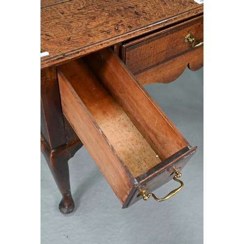 730 - An 18th century oak three drawer lowboy within a shaped apron, raised on cabriole legs to pad feet, ... 