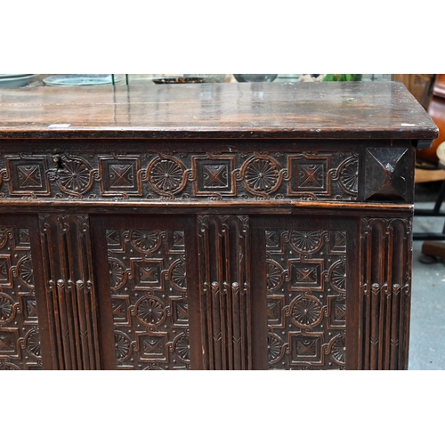 734 - An early 18th century oak coffer, the wide two plank staple hinged top over an ornate relief carved ... 