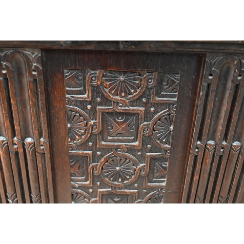 734 - An early 18th century oak coffer, the wide two plank staple hinged top over an ornate relief carved ... 