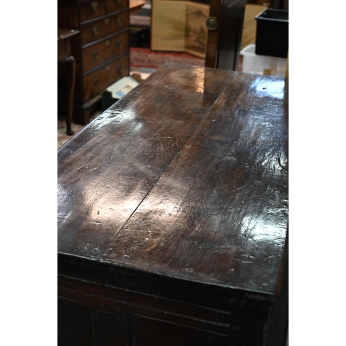 734 - An early 18th century oak coffer, the wide two plank staple hinged top over an ornate relief carved ... 