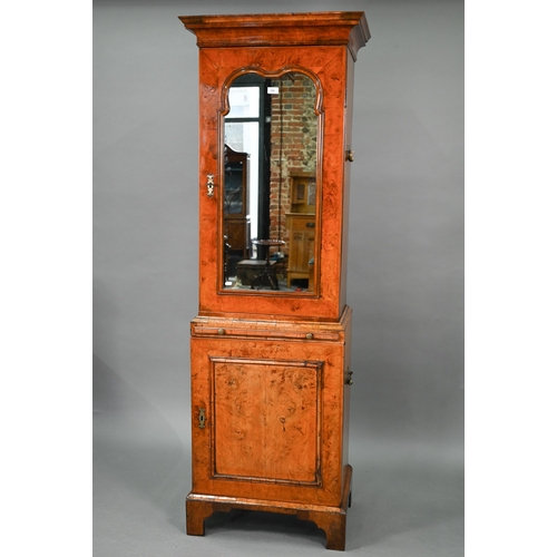 739 - An antique William & Mary style walnut cabinet, in two sections, the shaped canopy over a mirror... 