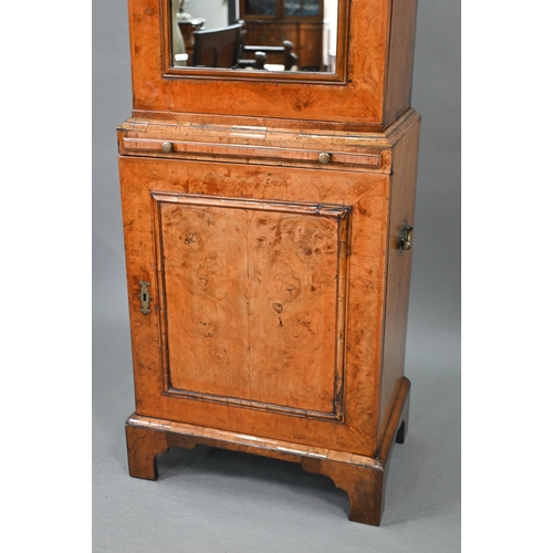 739 - An antique William & Mary style walnut cabinet, in two sections, the shaped canopy over a mirror... 