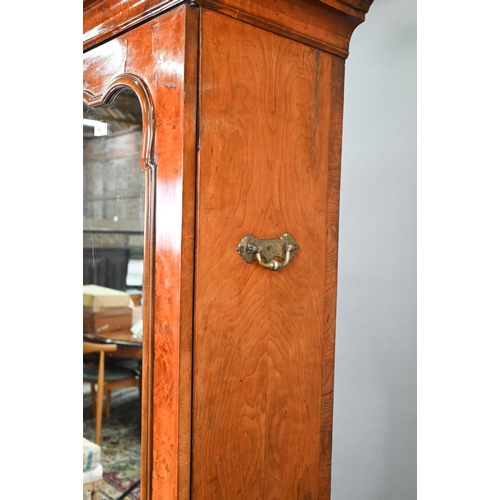739 - An antique William & Mary style walnut cabinet, in two sections, the shaped canopy over a mirror... 