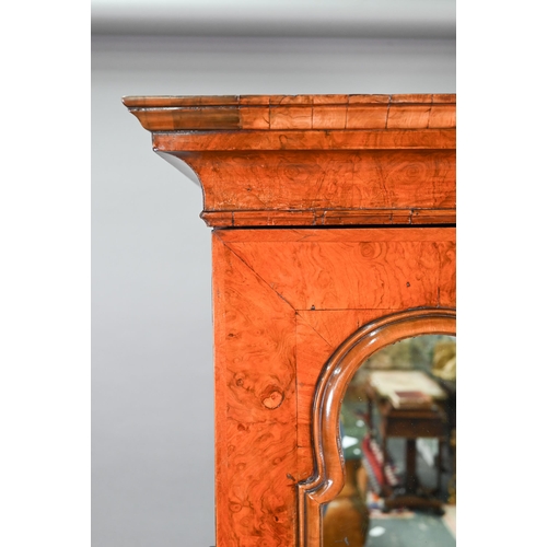 739 - An antique William & Mary style walnut cabinet, in two sections, the shaped canopy over a mirror... 