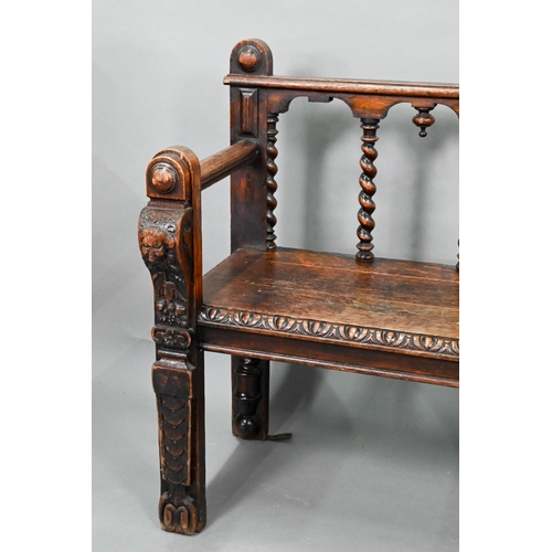 747 - A Victorian carved oak settle, the open back with five barley twist supports over flat arms, a plank... 
