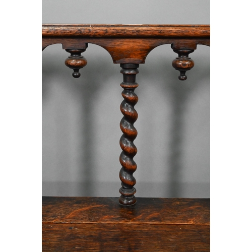747 - A Victorian carved oak settle, the open back with five barley twist supports over flat arms, a plank... 