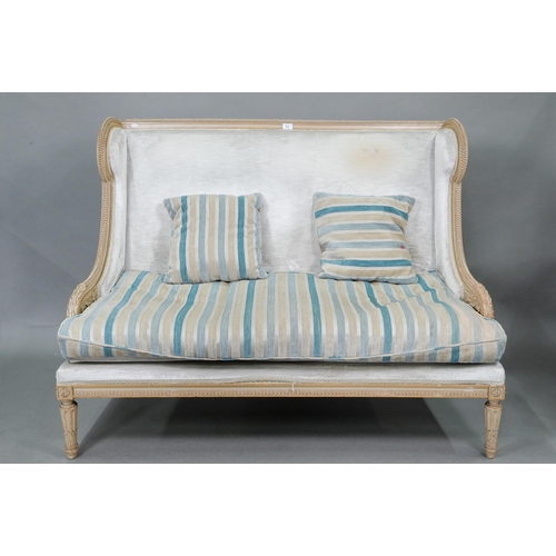754 - A French Empire style two seater sofa, the carved and moulded frame washed off-white, having a fabri... 