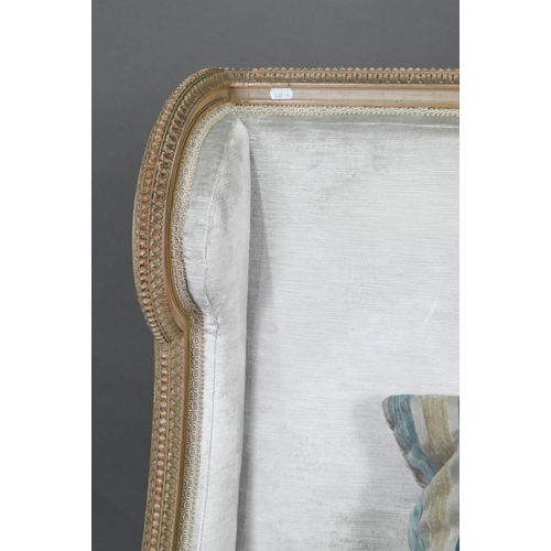 754 - A French Empire style two seater sofa, the carved and moulded frame washed off-white, having a fabri... 