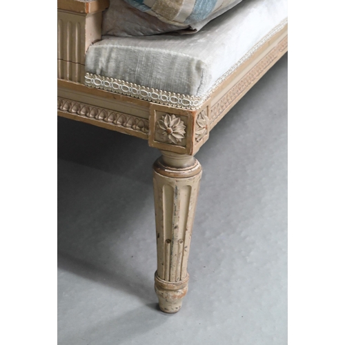754 - A French Empire style two seater sofa, the carved and moulded frame washed off-white, having a fabri... 
