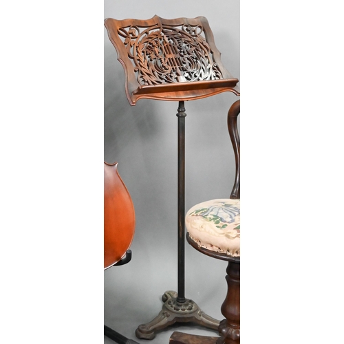 763 - A Victorian fret cut adjustable easel music stand, raised on a rise and fall pole and cast iron base