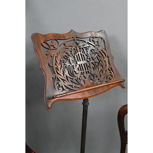 763 - A Victorian fret cut adjustable easel music stand, raised on a rise and fall pole and cast iron base