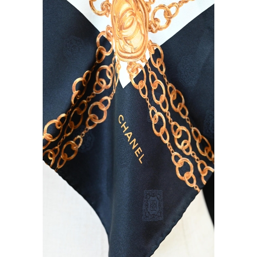 923 - Chanel - A black and cream silk scarf featuring gold chains, rolled edge, 87 x 87 cm Good condition... 