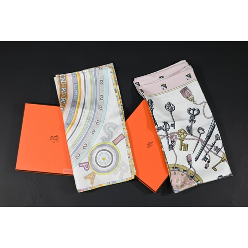 928 - Hermés - Two boxed silk scarves featuring pastel links and pink keys, rolled edges, 87 x 87 c... 