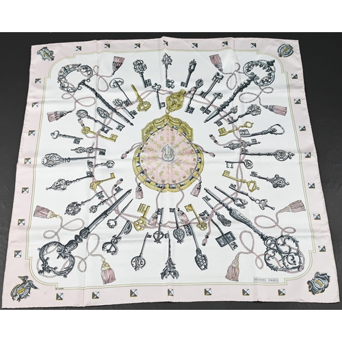 928 - Hermés - Two boxed silk scarves featuring pastel links and pink keys, rolled edges, 87 x 87 c... 