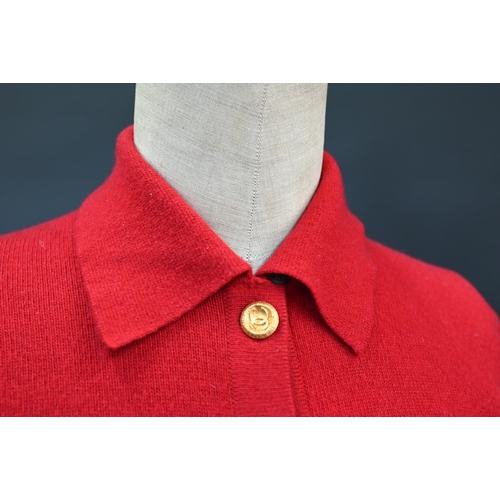 931 - Chanel - A red cashmere cardigan with collar and two pockets, gilt metal Chanel buttons to cuffs, po... 