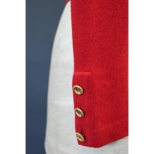 931 - Chanel - A red cashmere cardigan with collar and two pockets, gilt metal Chanel buttons to cuffs, po... 