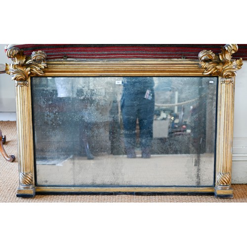 703 - A Regency carved and moulded giltwood overmantel, the original distressed mirror plate flanked by fl... 