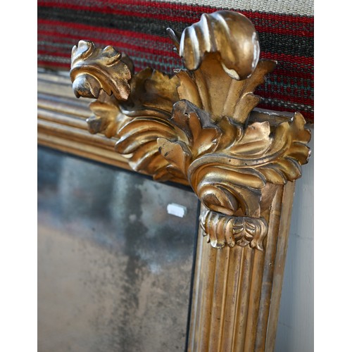 703 - A Regency carved and moulded giltwood overmantel, the original distressed mirror plate flanked by fl... 