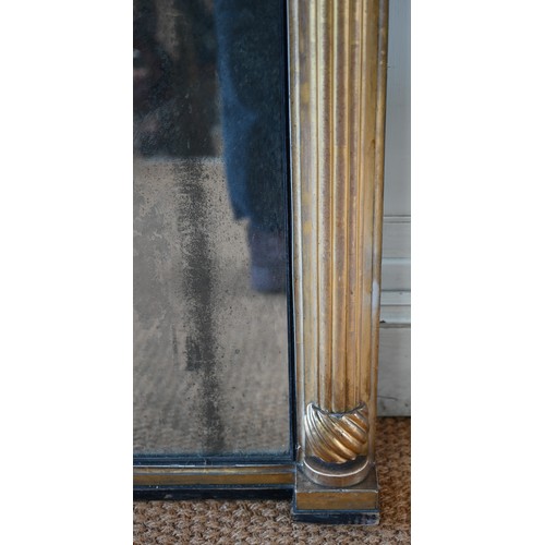 703 - A Regency carved and moulded giltwood overmantel, the original distressed mirror plate flanked by fl... 