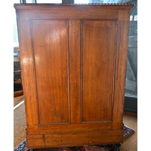 707 - An antique American Wells Fargo 'Wooton' style desk, golden oak, the hinged upper panel over a pair ... 