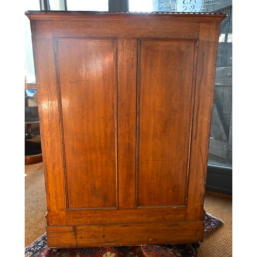 707 - An antique American Wells Fargo 'Wooton' style desk, golden oak, the hinged upper panel over a pair ... 