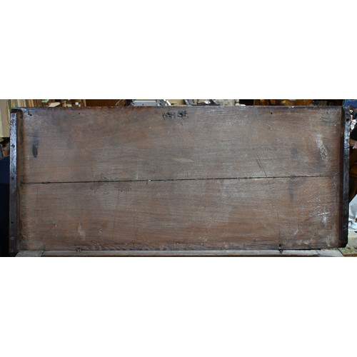 734 - An early 18th century oak coffer, the wide two plank staple hinged top over an ornate relief carved ... 