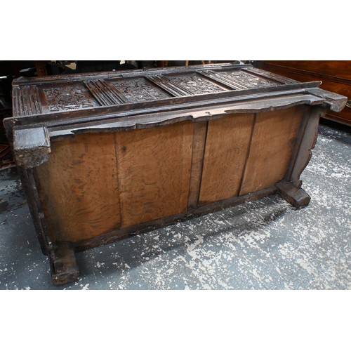 734 - An early 18th century oak coffer, the wide two plank staple hinged top over an ornate relief carved ... 