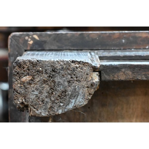 734 - An early 18th century oak coffer, the wide two plank staple hinged top over an ornate relief carved ... 