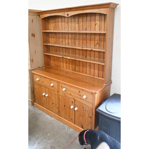 51 - A heavy quality stained pine kitchen dresser with plate rack above two frieze drawers and four panel... 