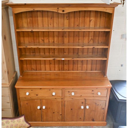 51 - A heavy quality stained pine kitchen dresser with plate rack above two frieze drawers and four panel... 