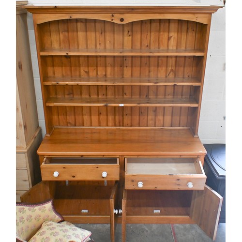 51 - A heavy quality stained pine kitchen dresser with plate rack above two frieze drawers and four panel... 