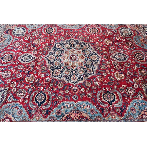 81 - A contemporary Persian Kashan carpet, the blue ground with multi-coloured geometric design, 384 cm x... 