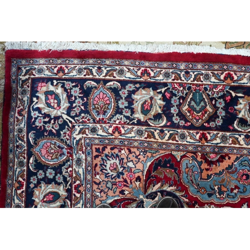 81 - A contemporary Persian Kashan carpet, the blue ground with multi-coloured geometric design, 384 cm x... 