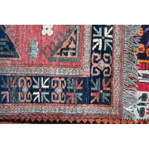 186 - A mid-century Turkish rug, the faded red ground rug with geometric design, 228 cm x 164 cm