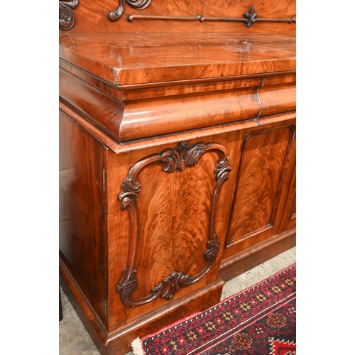 150 - A Victorian mahogany sideboard with scrolling raised back above three pulvinated frieze drawers on i... 